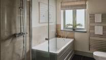 The master bedroom has the wonderful addition of an en suite with a bath and shower