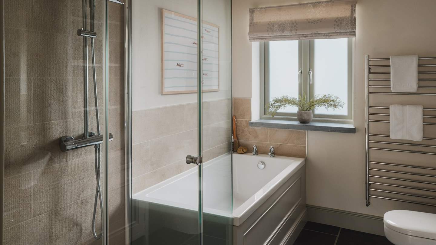 The master bedroom has the wonderful addition of an en suite with a bath and shower
