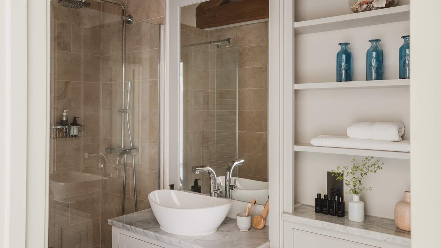 The family bathroom with a walk-in shower and heated towel rail to keep towels warm and fluffy