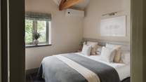 Dressed in soothing shades and cloud-soft linens, the second bedroom is a calming space for lingering lie-ins