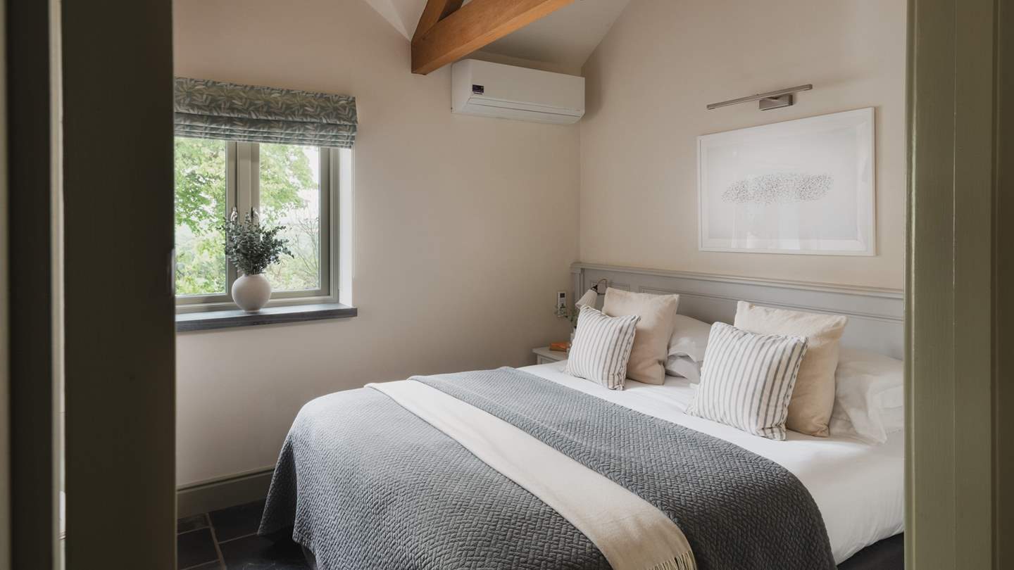 Dressed in soothing shades and cloud-soft linens, the second bedroom is a calming space for lingering lie-ins