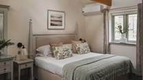 The master bedroom with a super-king size bed swathed in the finest of linens and plush pillows 