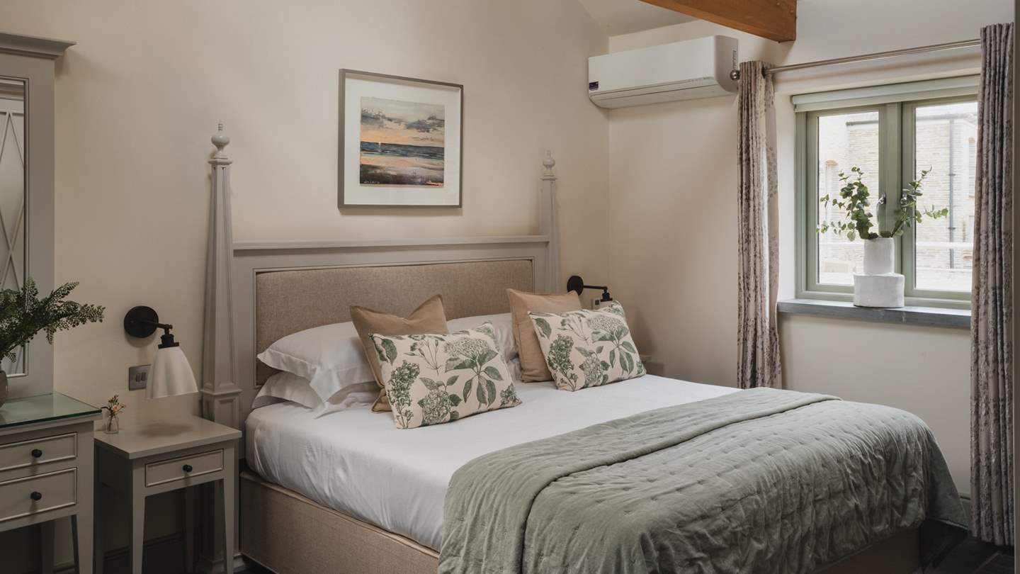 The master bedroom with a super-king size bed swathed in the finest of linens and plush pillows 