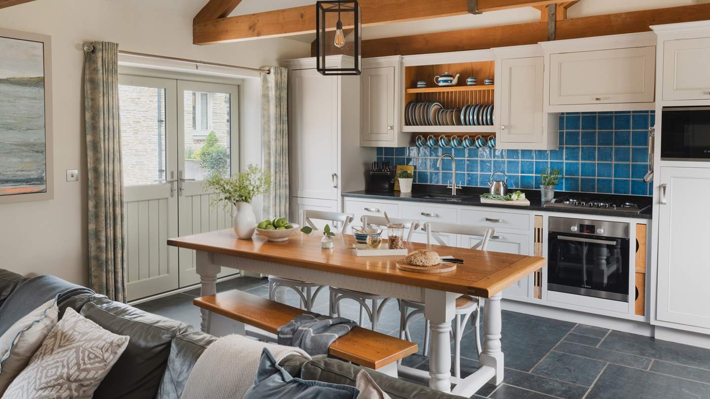 The grey kitchen with black granite worktops and sky-blue tiles has everything to prepare a meal for your loved ones