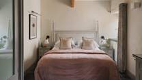 The Master bedroom decorated in pretty shades of pink and with scalloped-edged bedside lights, calls for slow mornings and restful nights 