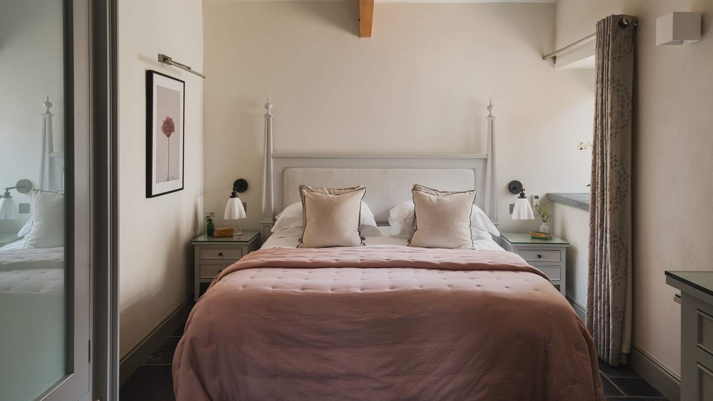 The Master bedroom decorated in pretty shades of pink and with scalloped-edged bedside lights, calls for slow mornings and restful nights 