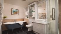 The family bathroom boasts a fabulous free-standing roll-top bath for long, luxurious soaks as well as a walk in shower.