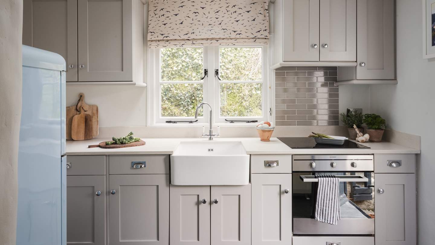 A low doorway leads through to the little Shaker-style kitchen where everything is provided to rustle up a feast