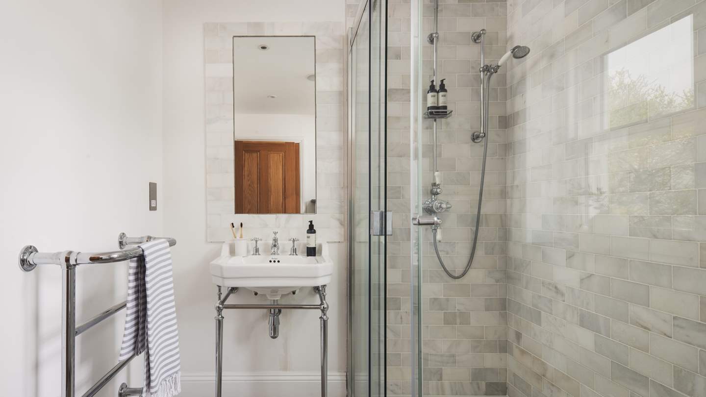 The en suite shower room with walk in shower and heated towel rail