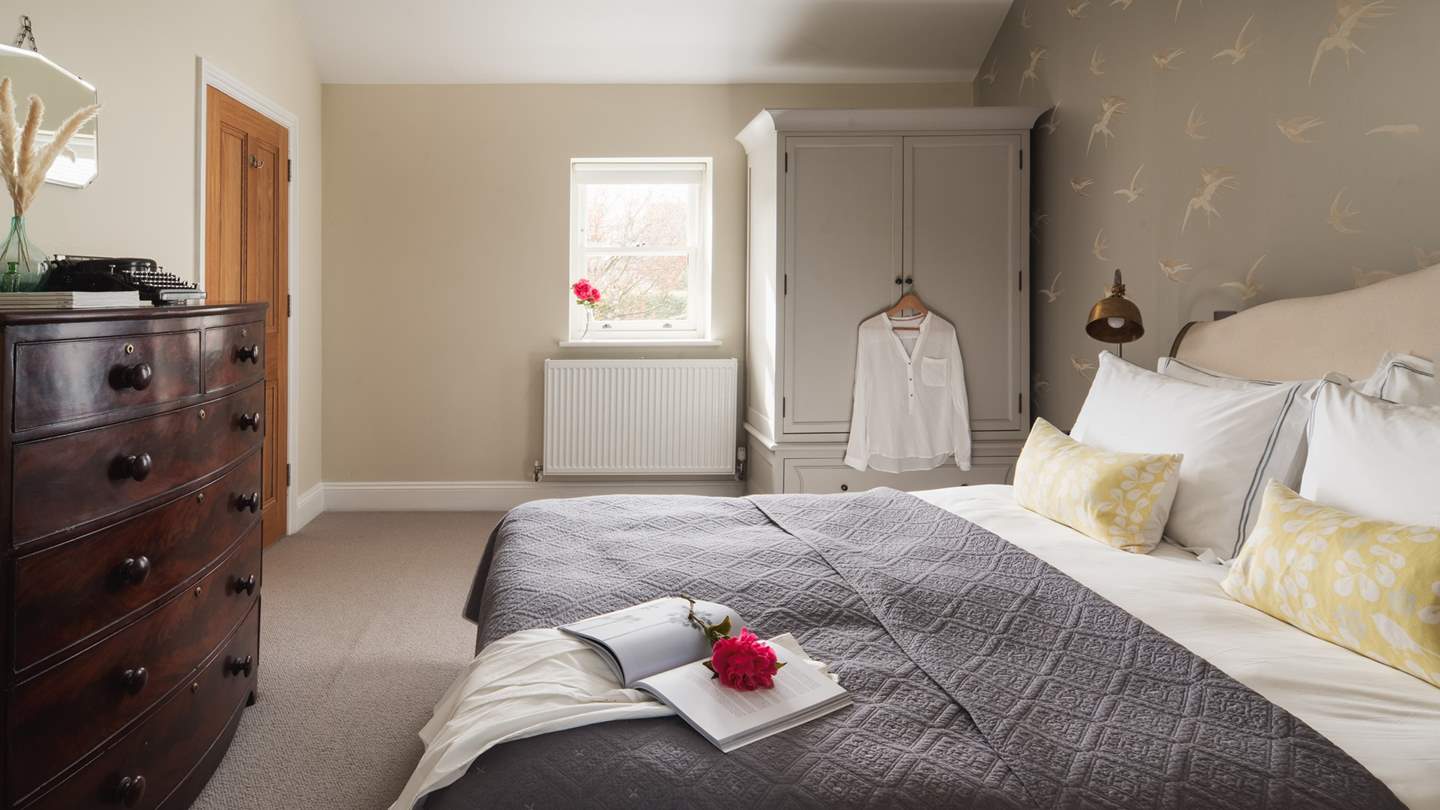 The king size master bedroom is spacious with vintage chest of drawers and wardrobe
