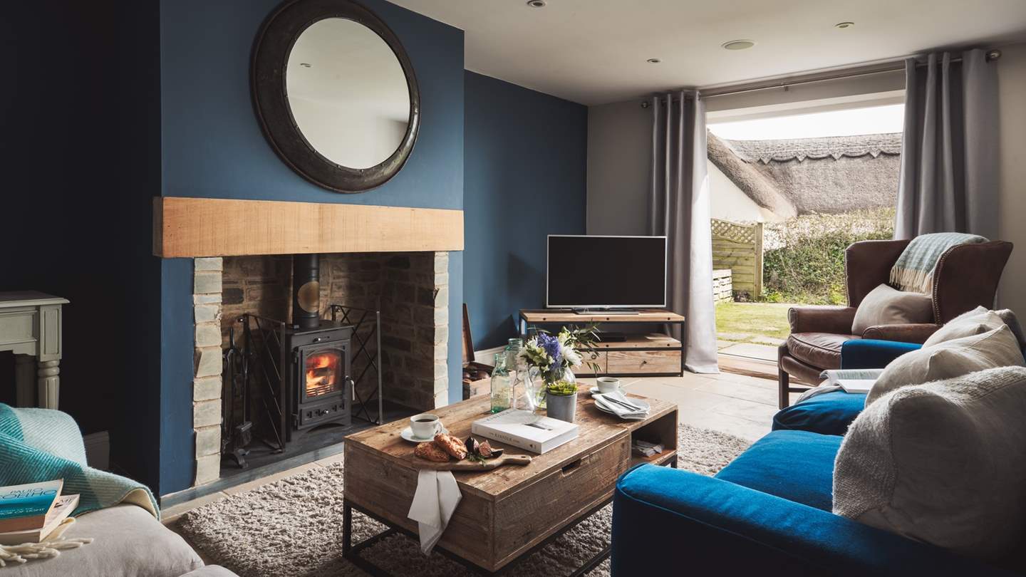 The cosy sitting room in decadent blues is a wonderful retreat at the end of an autumnal day, where its flickering wood burner awaits