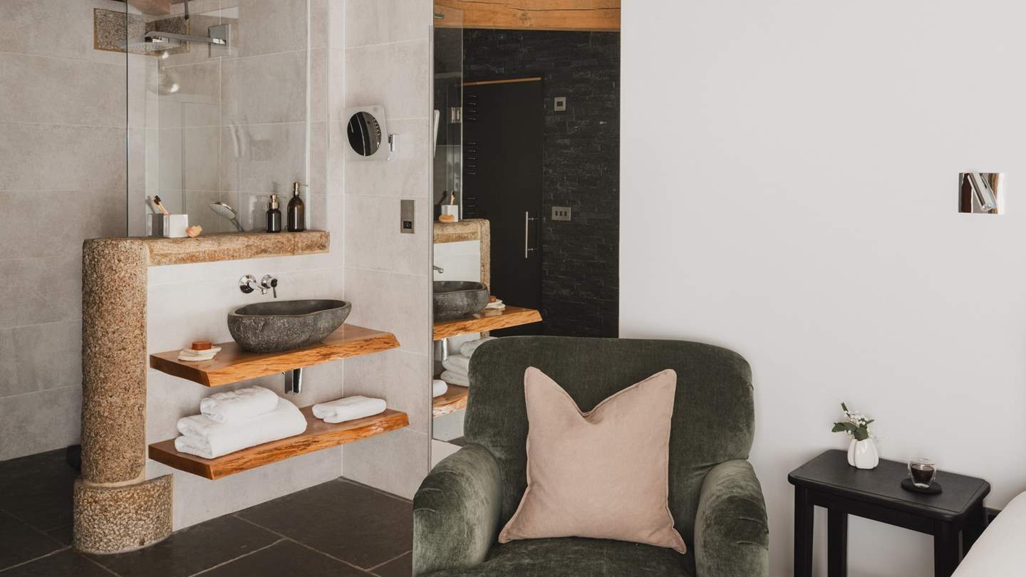 A space blending contemporary and traditional features with exposed granite and a unique river stone sink