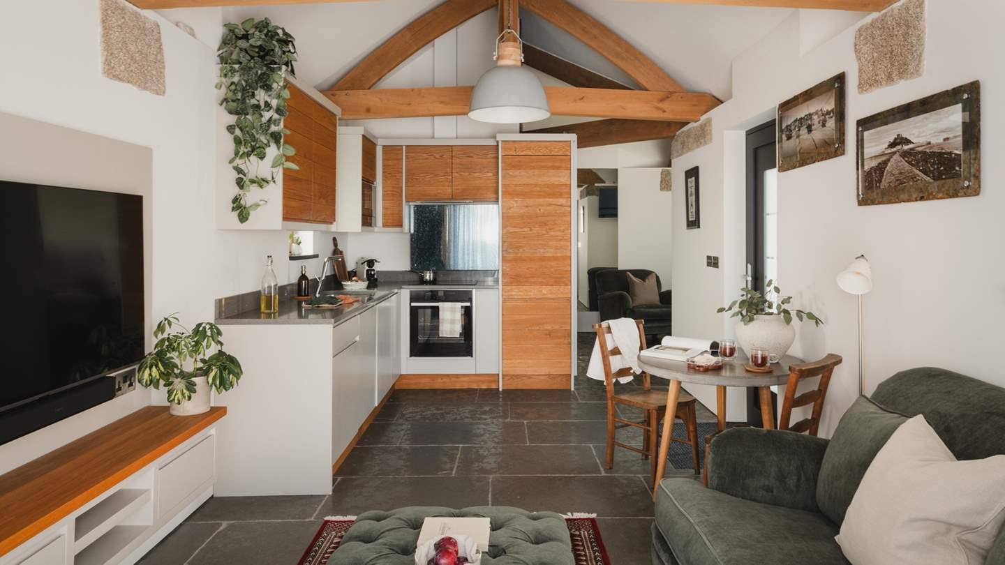 Uncover a sleek kitchen in soft shades of grey and warm wood, beautifully complementing the original features of the exquisitely converted barn