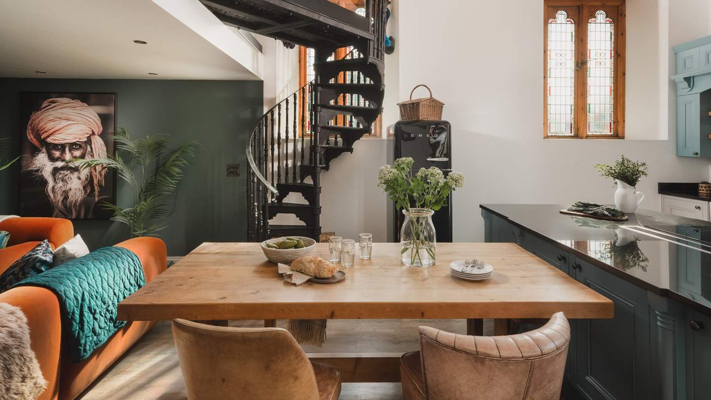 In front of the island is a huge wooden dining table with comfy leather chairs and bench – perfect for a romantic meal for two or a bustling family dinner