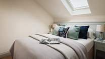 The cosy bedroom, hidden behind a stained-glass window, is resplendent in shades of eggshell blue and has a king size bed, swathed in gorgeously soft bedding, cushions and throws