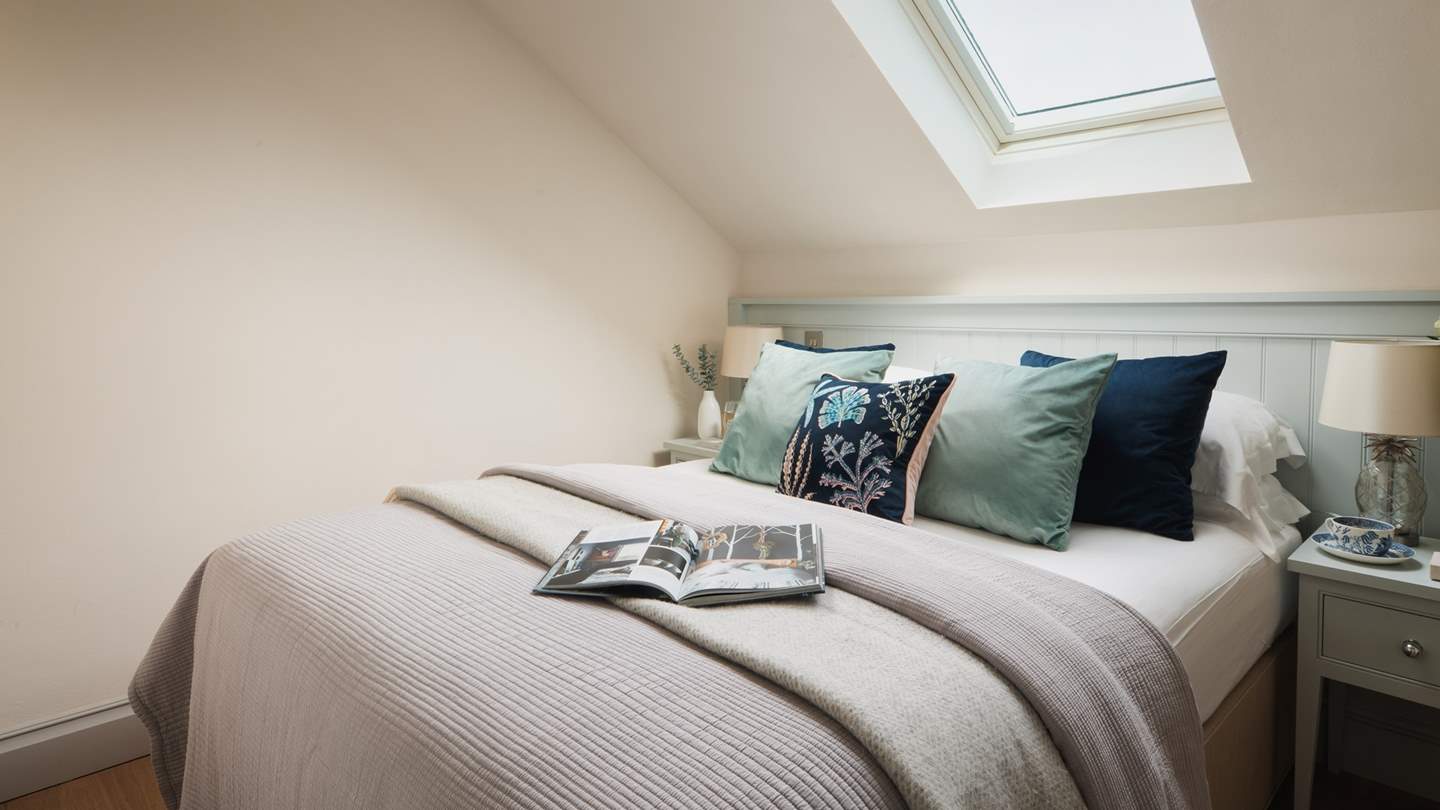 The cosy bedroom, hidden behind a stained-glass window, is resplendent in shades of eggshell blue and has a king size bed, swathed in gorgeously soft bedding, cushions and throws