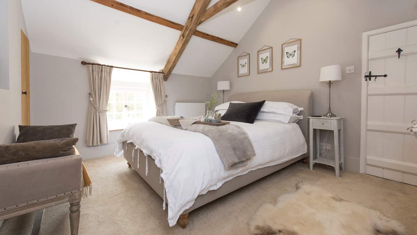 The blissful muted tones and vaulted ceilings makes it easy to fall asleep in this pretty bedroom.