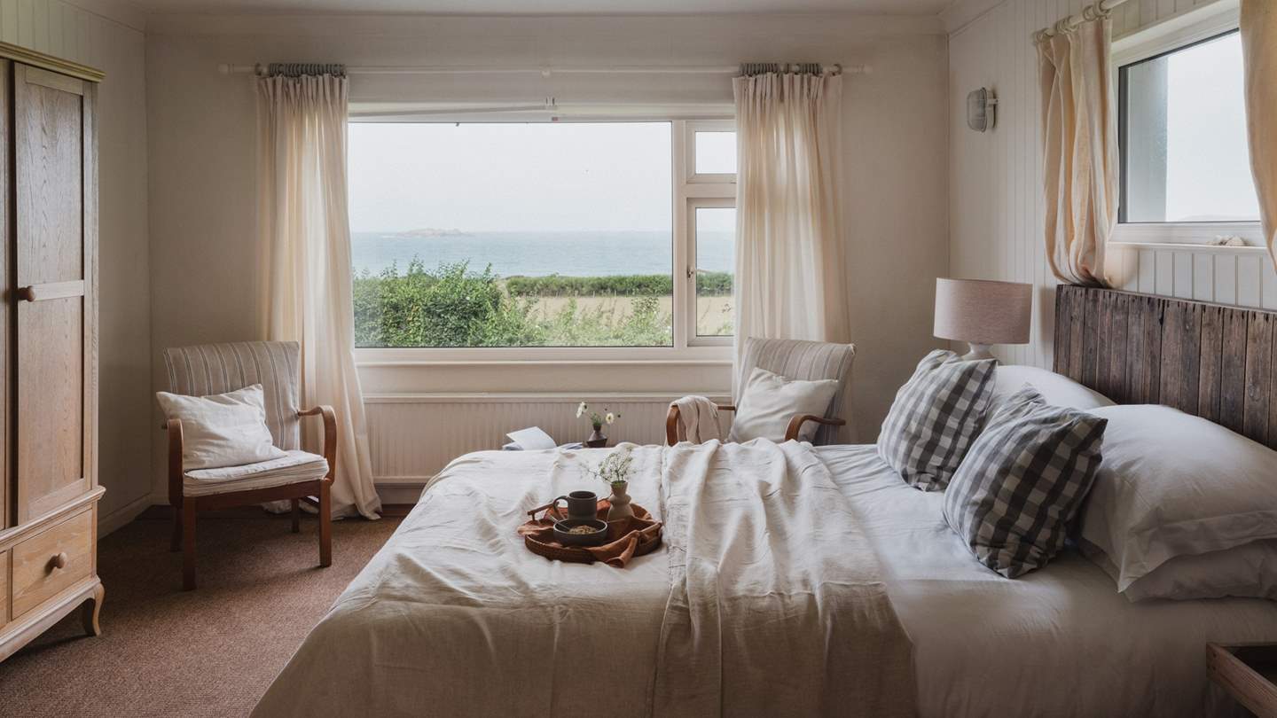 The first bedroom, located on the ground floor, features a sumptuous king-sized bed draped in the finest linens