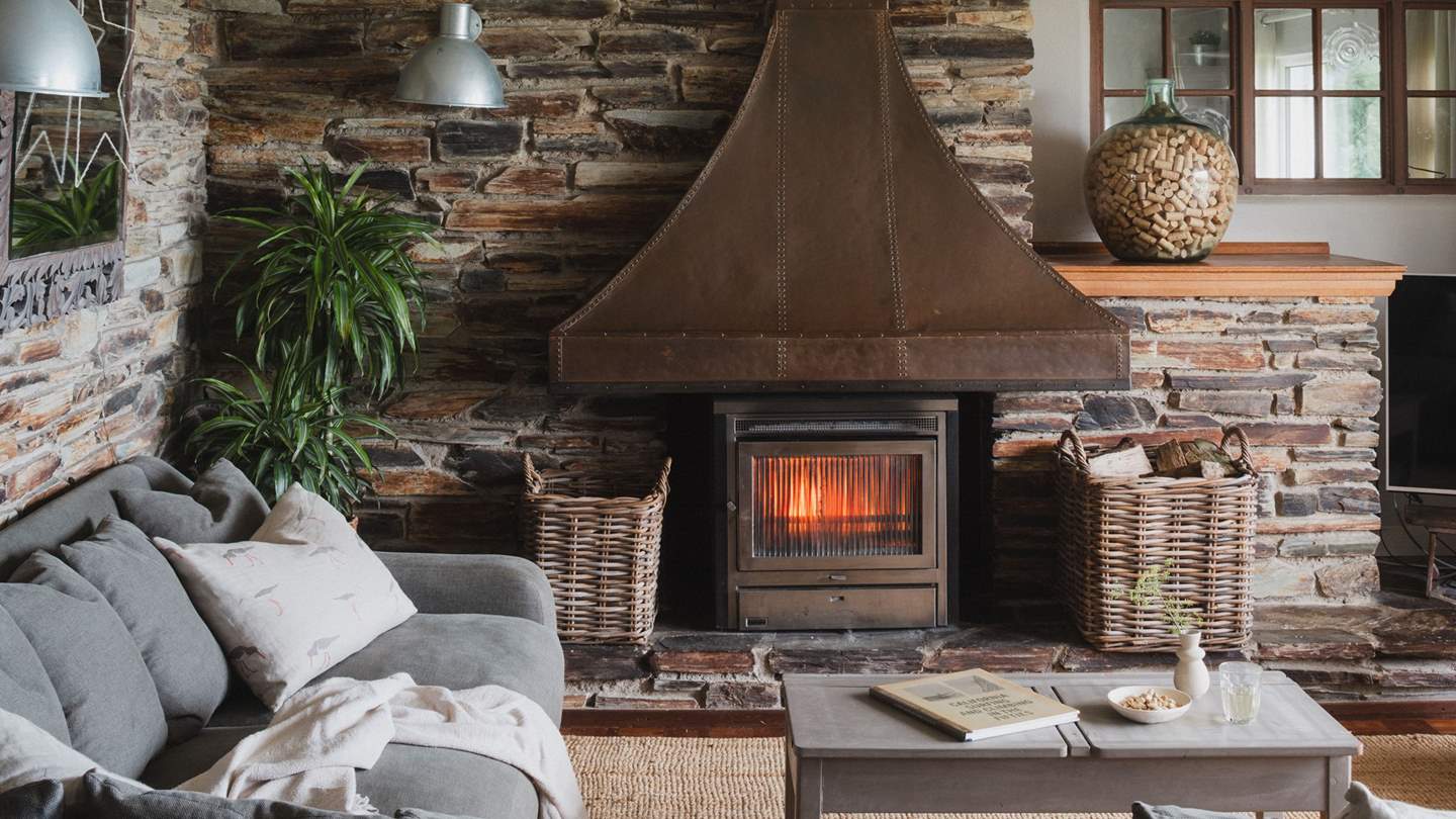 The cosy L-shaped corner sofa, armchairs, cushions, and throws imbue comfort throughout the year