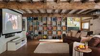 The beamed Games Barn is an incredible space with entertainment for the whole family, including a TV with a surround sound system for delightful movie nights 