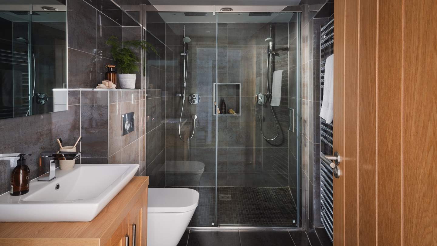The luxe bathroom has a stunning walk-in double shower room with two overhead rain shower heads