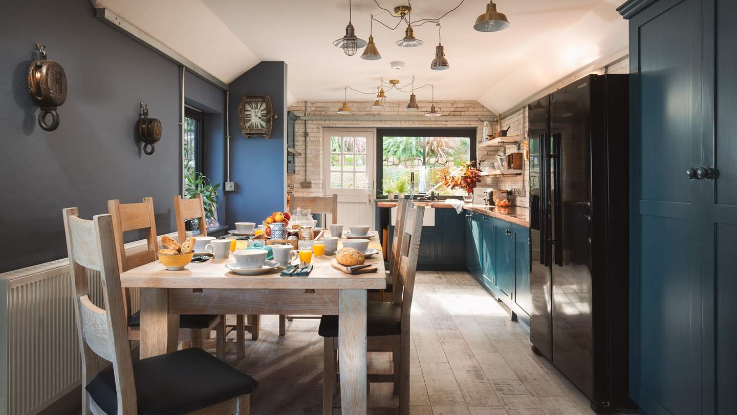 The rustic dining table lies next to the kitchen welcoming moments of family get-togethers 

