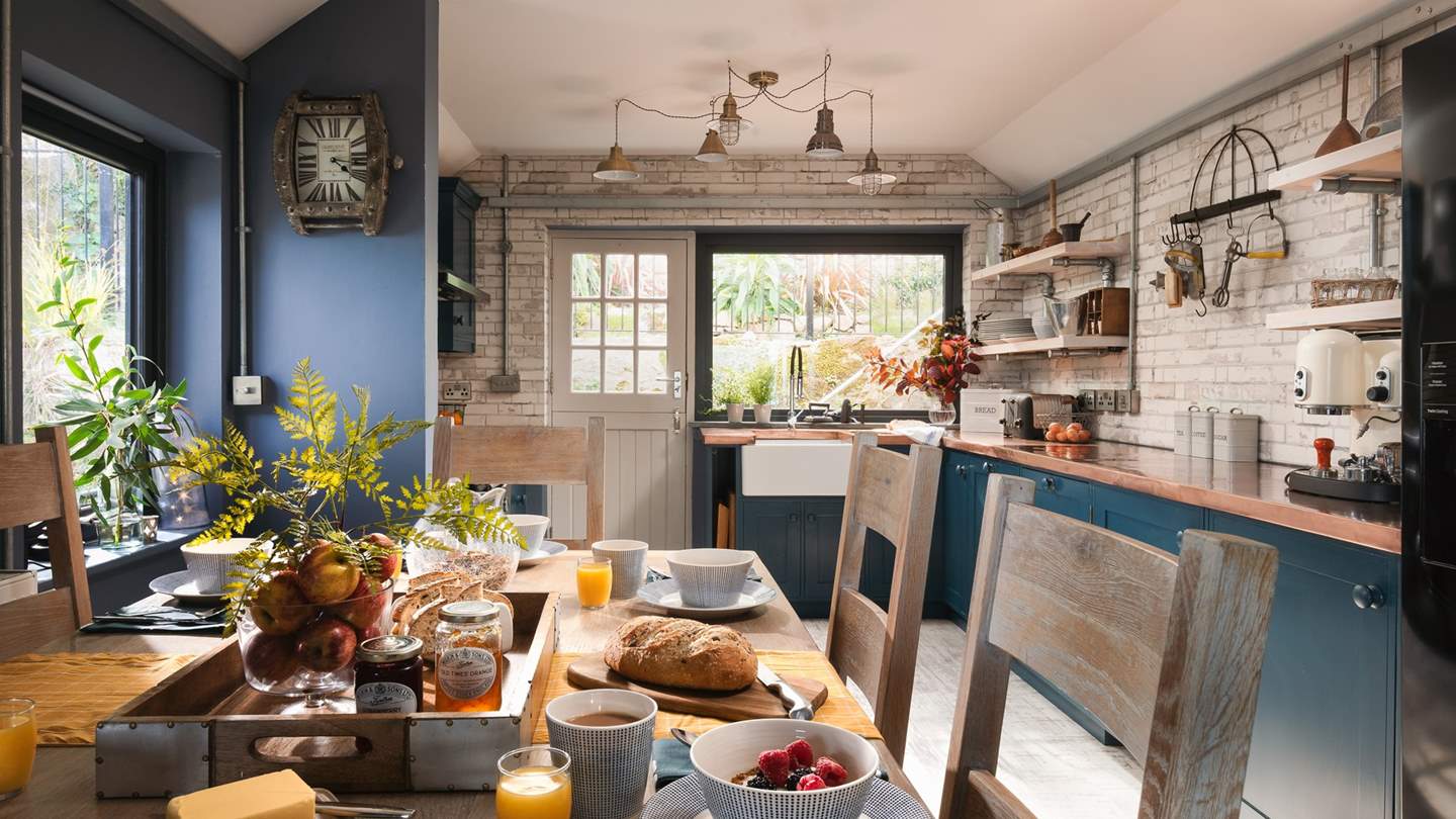 The beautiful bespoke kitchen lies to the back of the house, with gorgeously rich copper work tops, dark blue cupboards and whitewashed brick walls