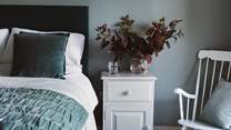 The king sized bed dressed  in swathes of turquoise, green and white, an invitation to restful slumbers