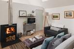 The lovely open-plan living area is a light, airy space open to the vaulted roof above - made perfect for relaxing in front of the wood burner