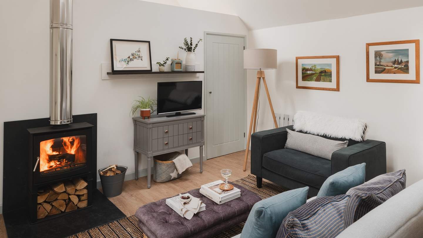 The lovely open-plan living area is a light, airy space open to the vaulted roof above - made perfect for relaxing in front of the wood burner
