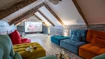 Tucked away in the eaves you'll an incredible cinema room, complete with funky velvet seats.