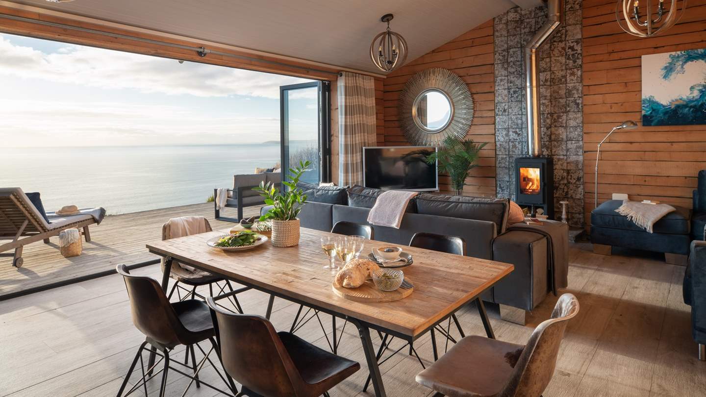 The stunning open-plan living space is simply a dream, with bi-fold doors that lead onto a large terrace overlooking the sea