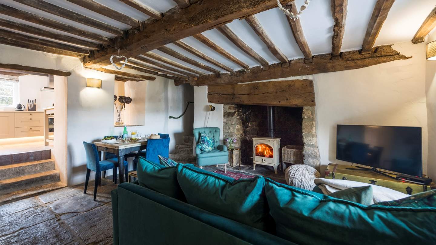 This lovely space has bags of character and the stylish teal Loaf sofa juxtaposes nicely with the pretty Turkish rugs, whitewashed walls and inglenook fireplace