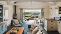 The open-plan living space is just fabulous with incredible countryside views from the bi-folding doors at the far end of the room