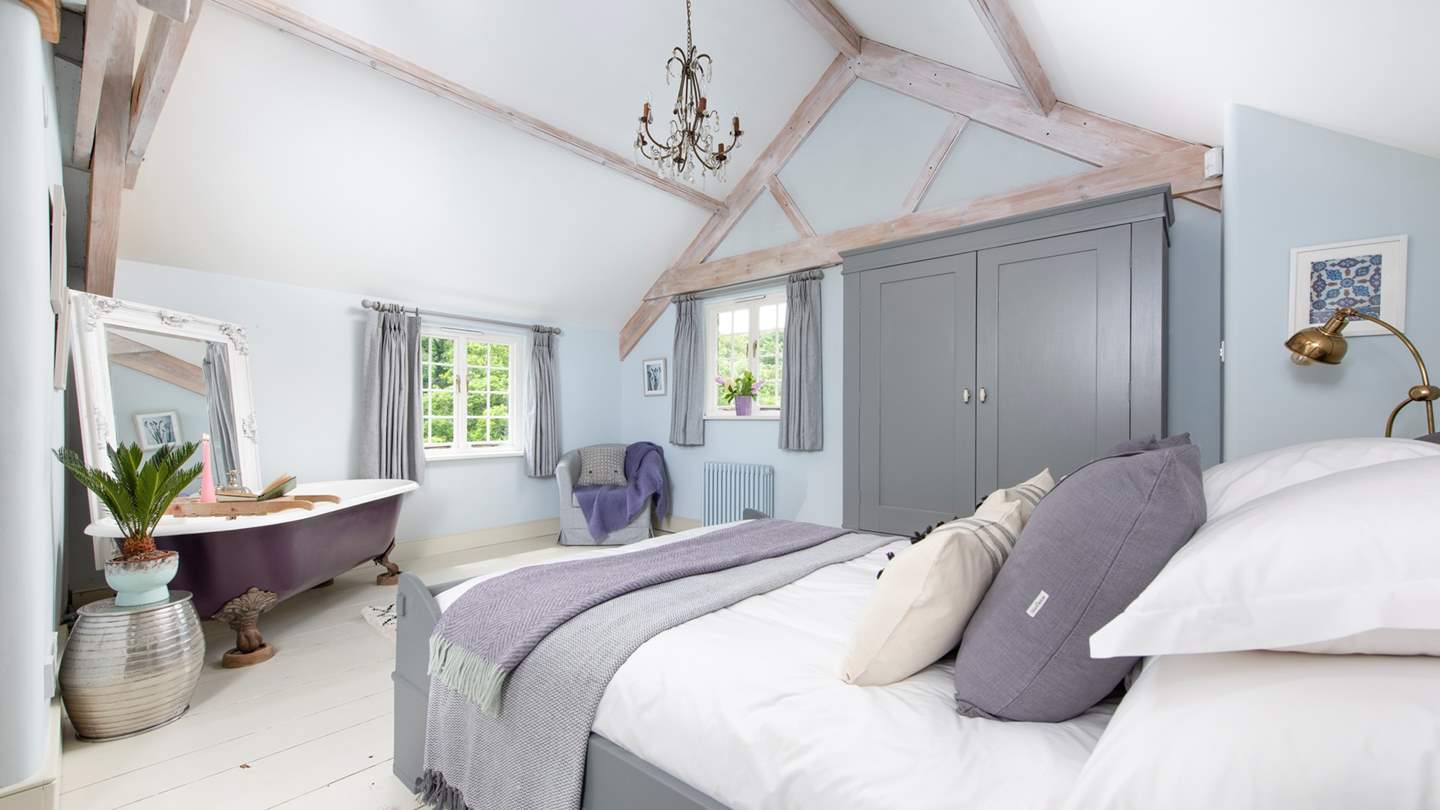 The beautiful en suite master bedroom is just dreamy in shades of purple and grey and comes complete with a romantic roll top bath for two.