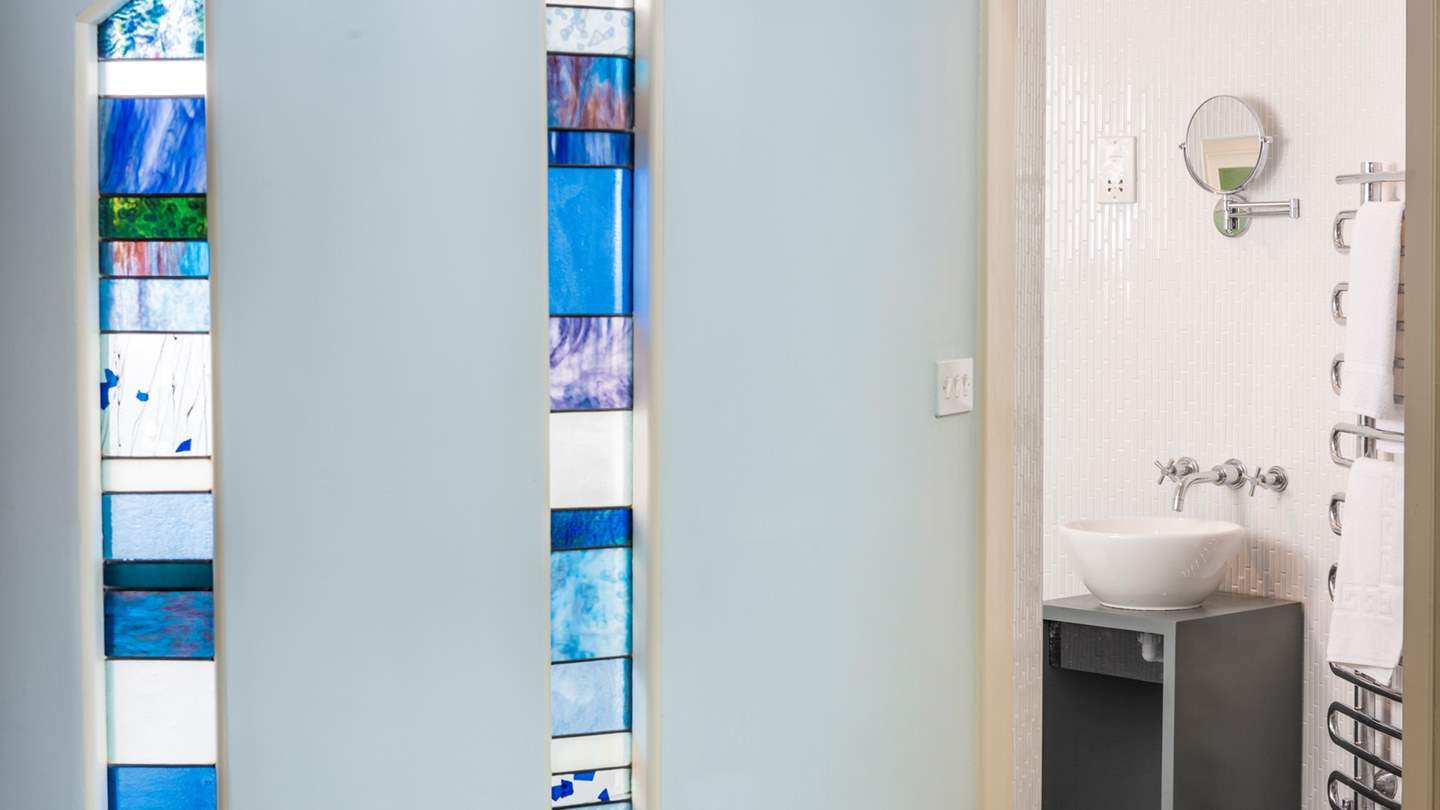 The en suite to the master bedroom is a real delight: hidden behind a gently curving wall inset with bespoke stained-glass windows hides a wet room for invigorating morning showers. 