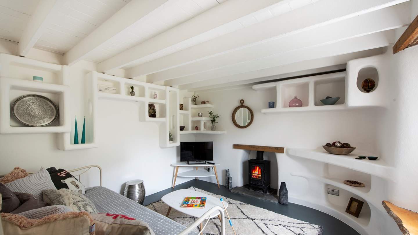 The second sitting room is a super-cute snug with whitewashed walls and eye-catching shelving housing lots of curious.