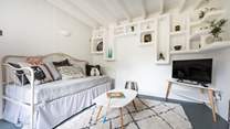 The second sitting room is a super-cute snug with whitewashed walls and eye-catching shelving housing lots of curious.