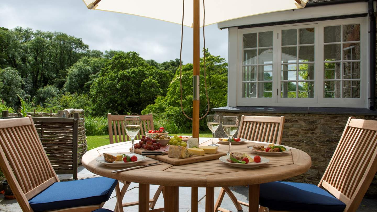 There's a sunny terrace outside the snug complete with dining table, chairs and a parasol.