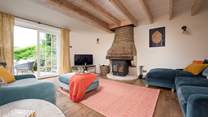 The comfortable, oak-floored sitting room is centred around an unusual, semi-circular stone chimney breast which houses a big wood burning stove.