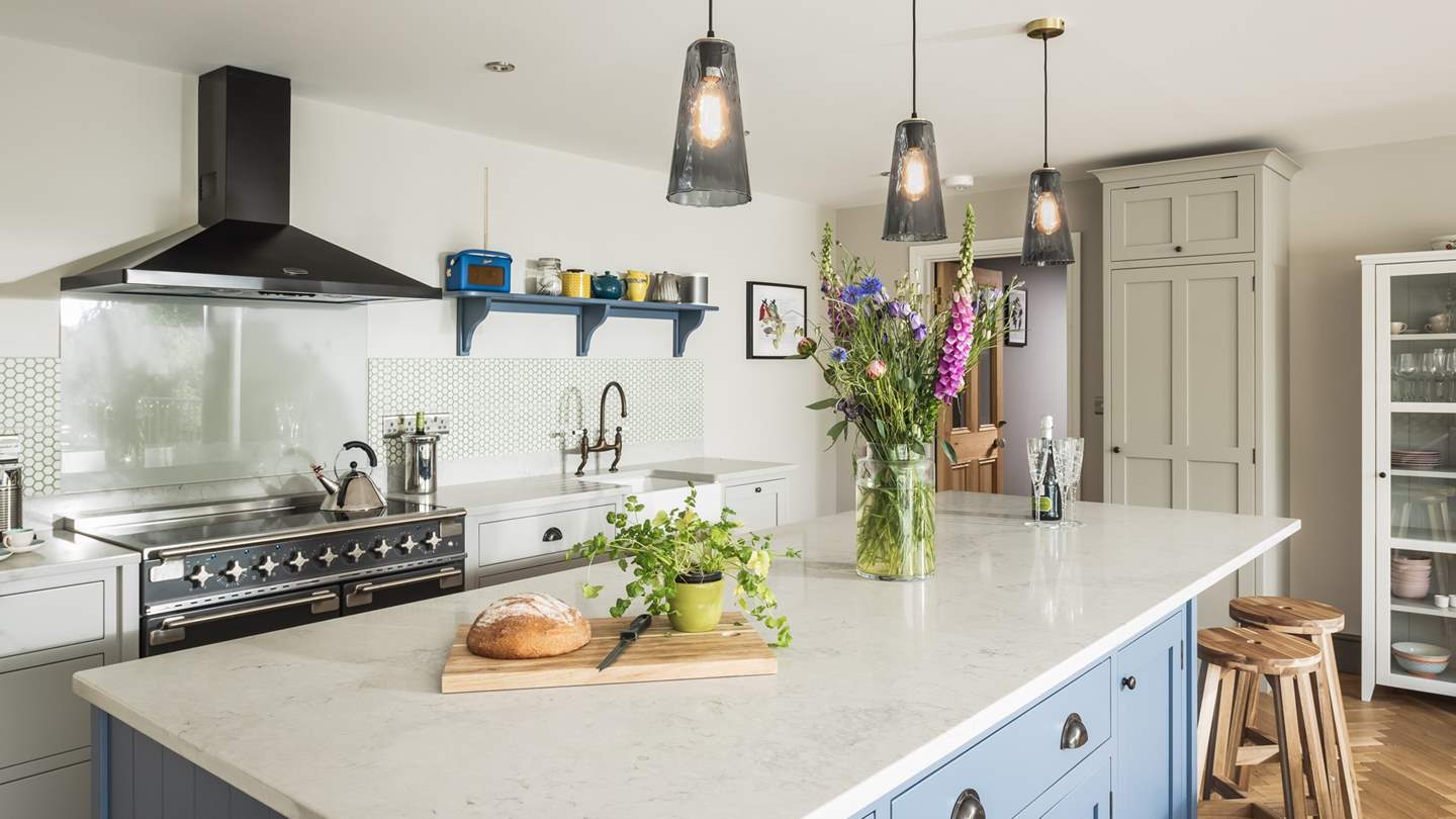 The kitchen is sleek and modern in shades of soft blue and pearly white 