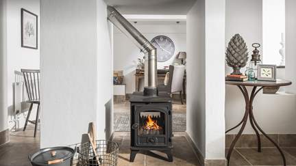 To the back of the cottage lies the snug, with its own pretty wood burner to keep things cosy.
