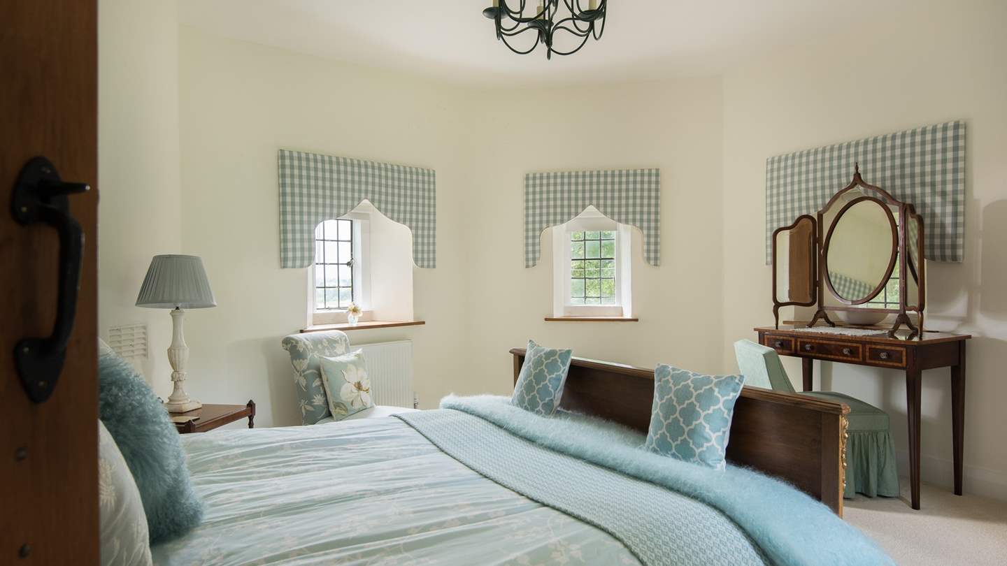French king-sized bed, gorgeous vanity table and unique windows; such a wonderfully feminine bedroom. 