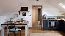 The kitchen, with gorgeous dark blue cabinets and sleek wooden worksurface, holds everything you need to create romantic meals for two 