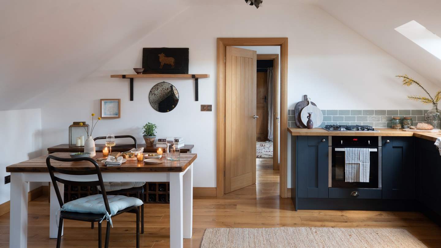 The kitchen, with gorgeous dark blue cabinets and sleek wooden worksurface, holds everything you need to create romantic meals for two 