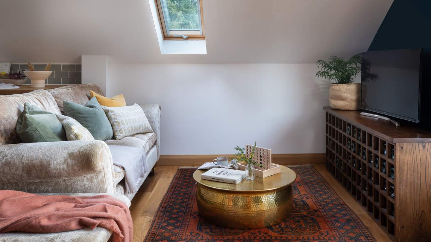 The living area has a cosy velvet sofa and eye-catching bronze coffee table where you can snuggle up together