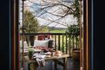 Stable doors open out onto a balcony where you're met by a verdant canopy of trees