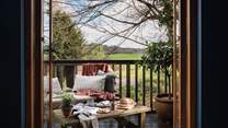 Stable doors open out onto a balcony where you're met by a verdant canopy of trees