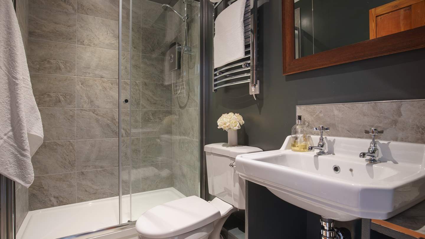 The gorgeously grey shower room has a large walk-in shower for rejuvenating wake-up moments