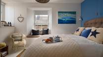 Uncover the first of two stylish bedrooms with blue accents and cream interior finishes